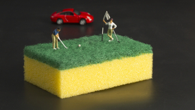 Miniworld - Golfputt på Fixa grön allrengöringssvamp. Röd Porsche i bakgrunden.220503 © Foto Patric Lindén / Internetfoto
